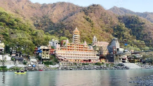 Tera manzil temple and colorful rafting boat on Ganga river in Rishikesh India photo
