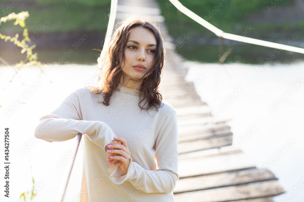 Portrait of a beautiful young brunette woman in the park. Asian girl in a white sweater