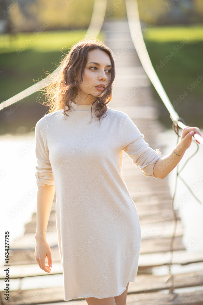 Portrait of a beautiful young brunette woman in the park. Asian girl in a white sweater