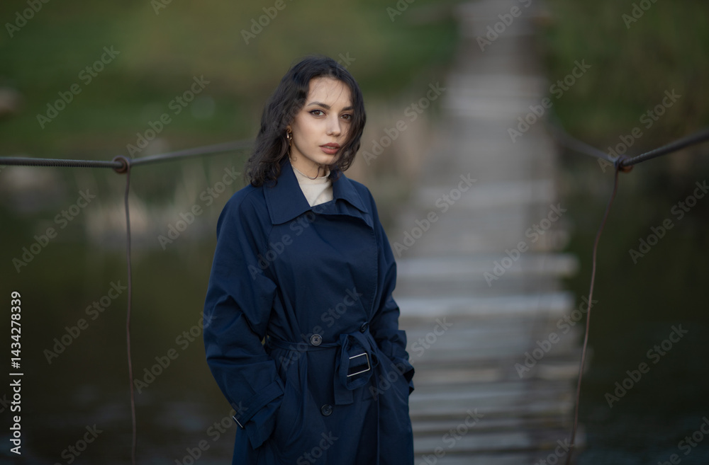 Portrait of a beautiful Asian woman with long black hair and wearing blue coat.