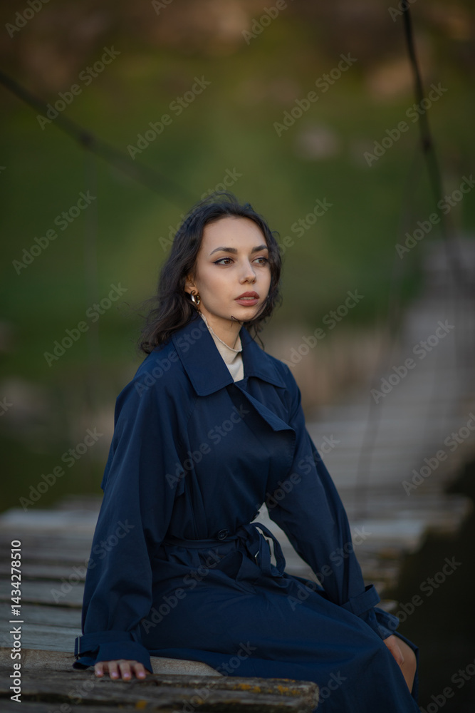 Portrait of a beautiful Asian woman with long black hair and wearing blue coat.