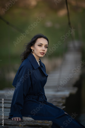 Portrait of a beautiful Asian woman with long black hair and wearing blue coat.