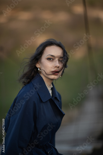 Beautiful brunette meditates sadly in the park in the evening light. Sad girl