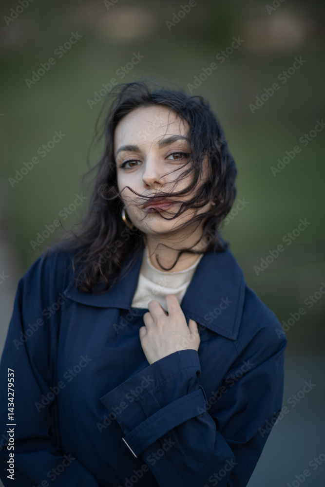 Portrait of a beautiful Asian woman with long black hair and wearing blue coat.