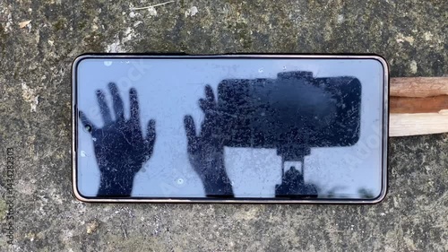 Shadow Hands Waving on Smartphone Screen