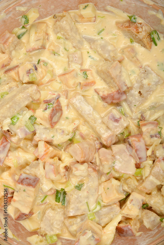 Obraz na płótnie A tightly cropped top-down view shows a creamy mixture of cubed bread, vegetables, and cheese in a clear bowl, ready to be baked into a strata w salonie