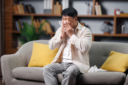 Obraz na plátně ill sick man, feeling unwell, having headache, Individual shows signs of distress while seated on a comfortable couch in a well-lit living space