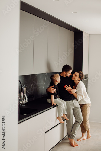 Happy family embracing in modern kitchen: father, mother, and son sharing tender moment