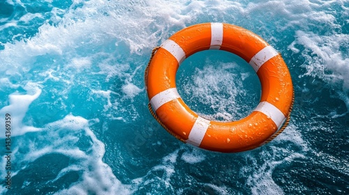 Bright orange life preserver floating in foamy turquoise water photo