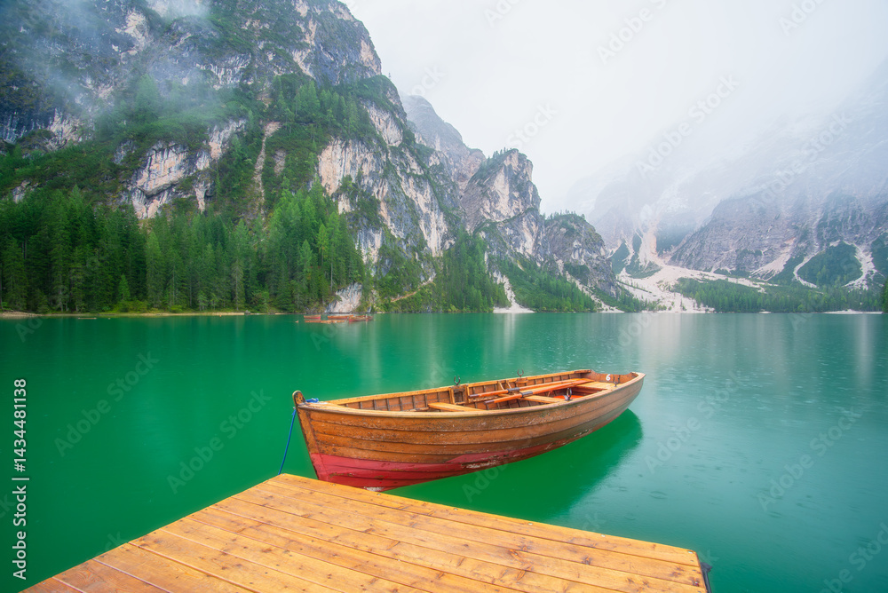 Boat on Lake Braies, Dolomites, Italy. Lake and reflections on the water surface. Mountain landscapes in summer. Place for mountain hiking, travel and vacation. Wallpaper, postcard, photo.