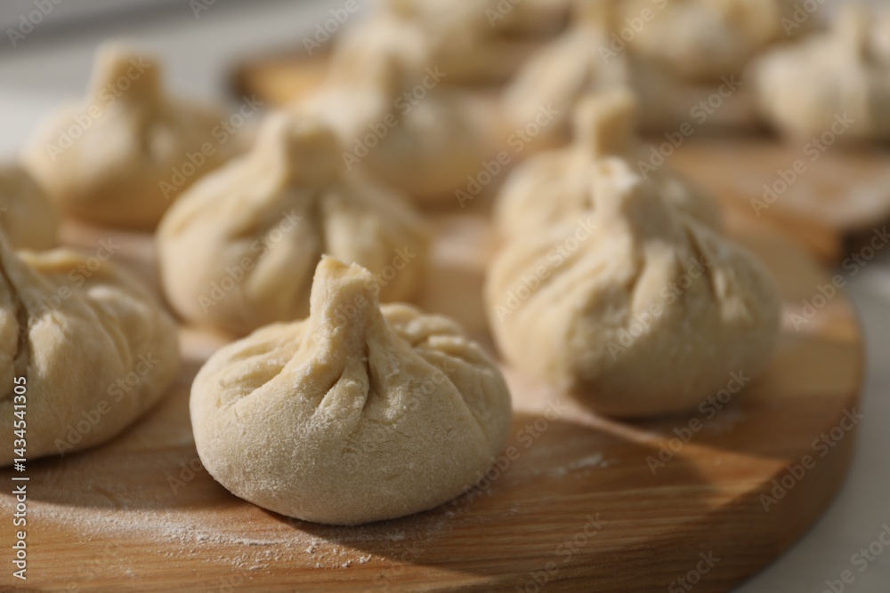 Many uncooked khinkali on countertop indoors, closeup Many uncooked khinkali on countertop indoors, closeup