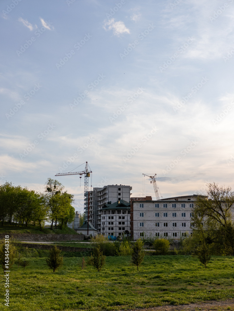 A large building with a crane in the background A large building with a crane in the background