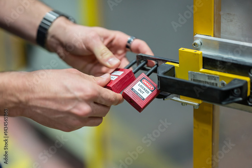 Photos Hands locking LOTO lockout tagout lock on the door, hand closeup