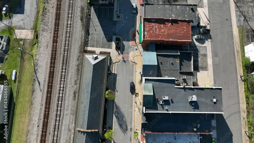 Rusty roofs of buildings along railway at train station of american town. Aerial top down flyover. Sunlight on spring day in Virginia, USA. Rusty roofs of buildings along railway at train station of american town. Aerial top down flyover. Sunlight on spring day in Virginia, USA.