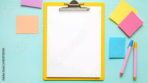 Bright clipboard with blank paper surrounded by colorful sticky notes and pens