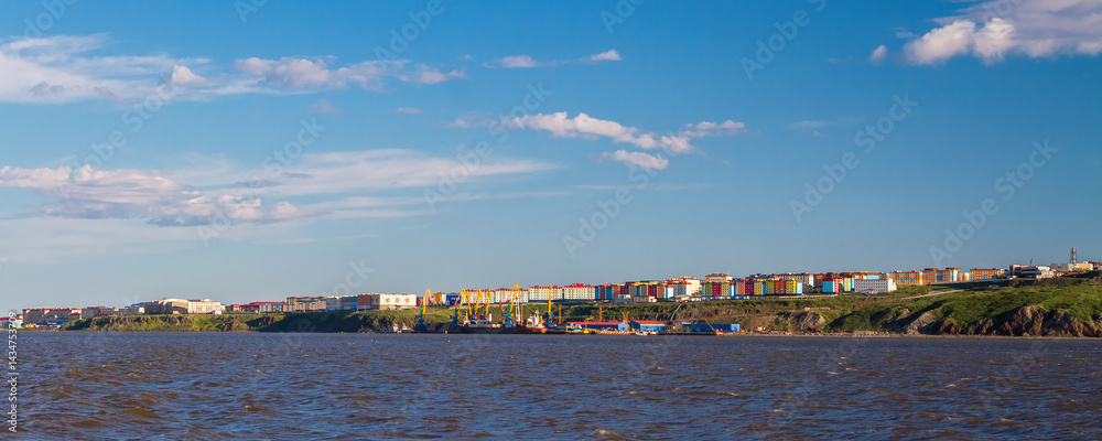 Panorama of the city of Anadyr. Chukotka, Russian Far East. View of the city from the Anadyr Estuary. In the distance is a seaport and colorful buildings. Summer arctic landscape.