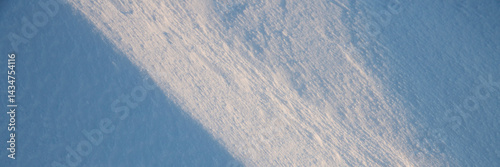 Obraz na płótnie Beautiful winter background with snowy ground. Natural snow texture. Wind sculpted patterns on snow surface. Wide panoramic texture for background and design. Closeup top view with copy space. w salonie