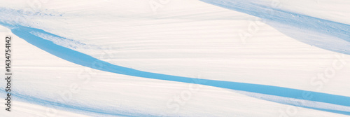 Obraz na płótnie Wide panoramic winter background with snowy ground. Natural snow texture. Wind sculpted patterns on snow surface. w salonie