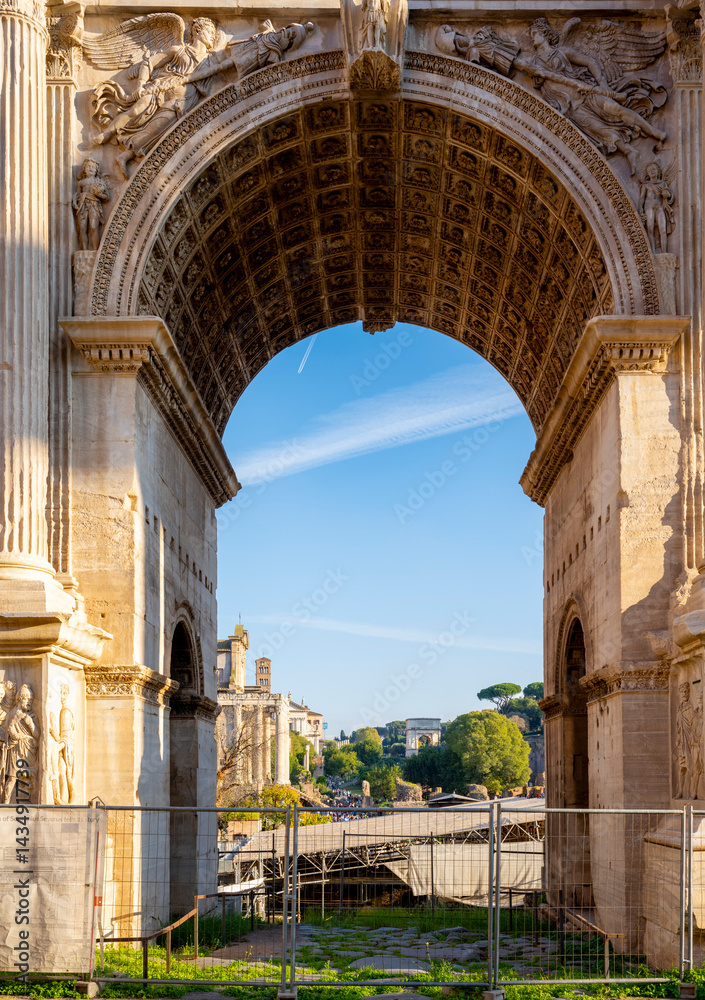 Obraz premium The Arch of Septimius Severus at the northwestern end of the Roman Forum is a white marble triumphal arch dedicated in 203 AD to commemorate the Parthian victories of Emperor Septimius Severus and his