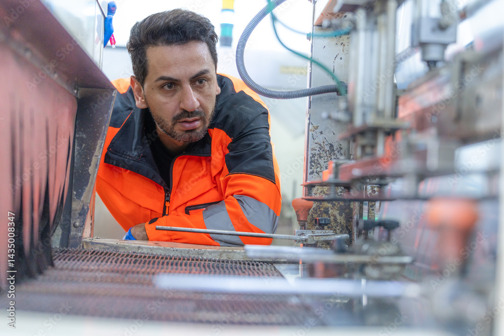 Workers in safety gear inside a factory check equipment and products on production and transportation lines in a closely monitored, state-of-the-art food processing plant.