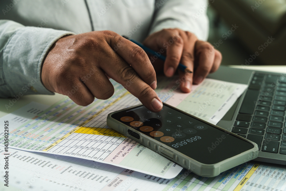 businessman uses a calculator and paperwork to analyze finances, investments, and tax reports at his desk calculator and digital tablet. business financial reports and data analysis