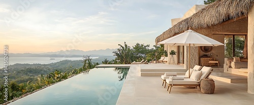 Luxurious villa with infinity pool overlooking a scenic ocean view, featuring sunbeds and an umbrella