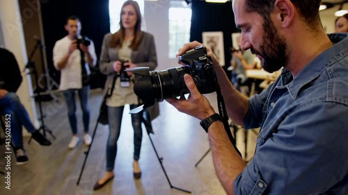 Photography teacher showing camera settings to students