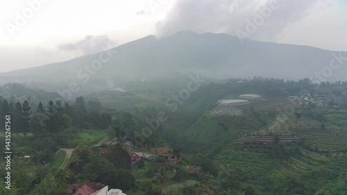 Misty Mountain Landscape: Aerial View of Verdant Hills and a Majestic Peak
