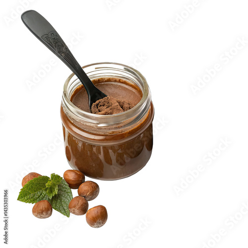 Rich hazelnut cocoa spread rests in a clear glass jar complemented by a black spoon with hazelnuts and fresh mint leaves arranged beside it