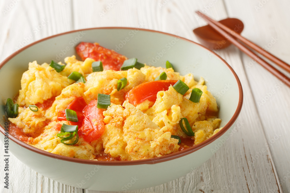 scrambled eggs with tomatoes, chinese food closeup on the plate on the wooden table. Horizontal scrambled eggs with tomatoes, chinese food closeup on the plate on the wooden table. Horizontal