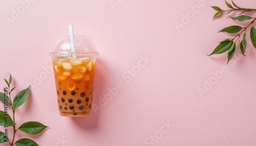 Minimalist top down photo of bubble tea in a plastic cup, placed on the left side over soft pastel background
