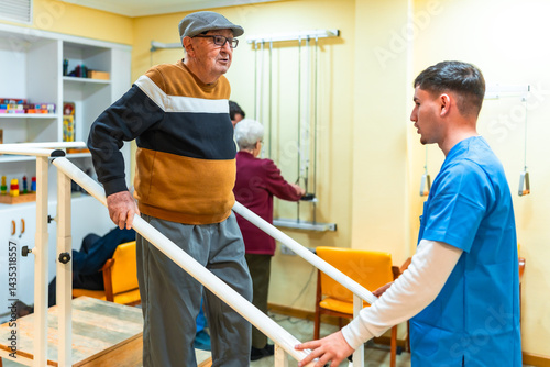 Obraz na płótnie Elderly man doing physical therapy exercises with professional physiotherapist in nursing home w salonie