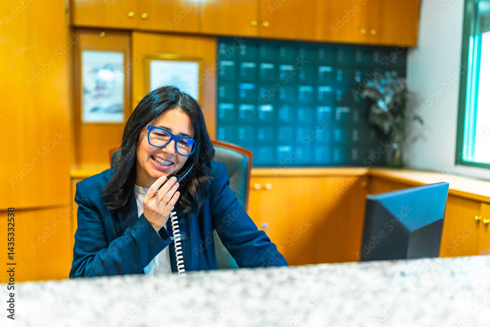 Receptionist smiling and talking on phone at nursing home reception desk
