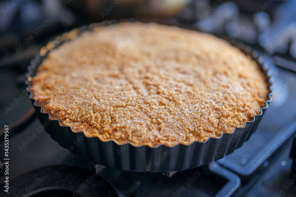 Cake with almond crust and creamy interior in a steel baking tin. An old German recipe for