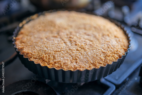 Cake with almond crust and creamy interior in a steel baking tin. An old German recipe for 