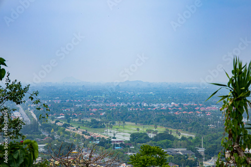 An aerial view of the city skyline of Phetchaburi, with mountains in the background.