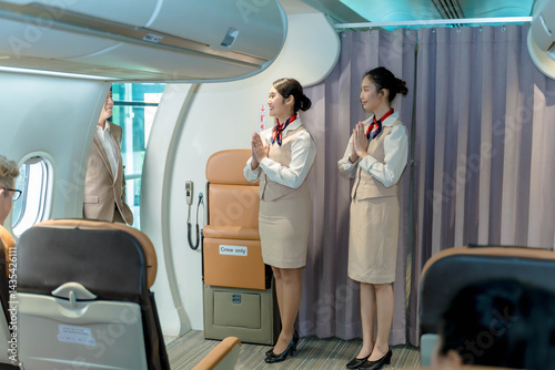 Flight attendants greeting passengers with traditional Thai 