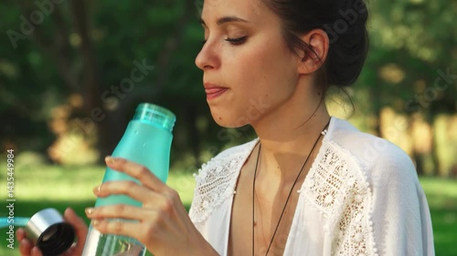 Girl enjoying a refreshing drink during yoga practice photo