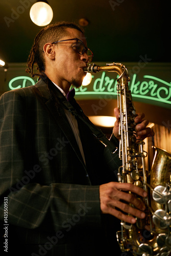 Canvas Print Vertical shot of expressive male sax player in suit performing music during jam