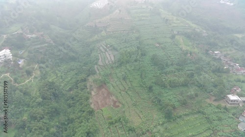 Misty Mountain Landscape: Aerial View of Lush Green Terraces and Village