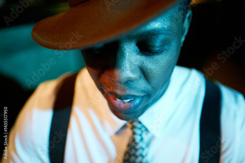 Photography Close up on African American male jazz musician wearing suit and hat concentrate