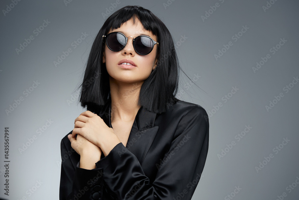 custom made wallpaper toronto digitalBlackhaired woman wearing sunglasses and a blazer poses confidently with hands on hips against a gray background