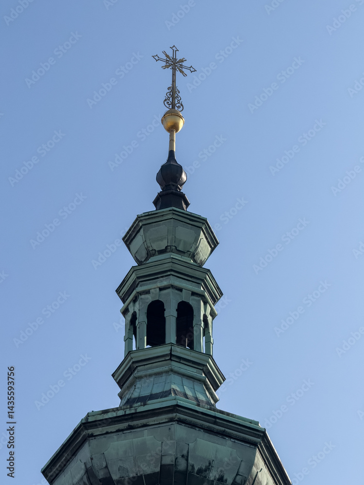 crucifix stands tall on the bell tower of a church