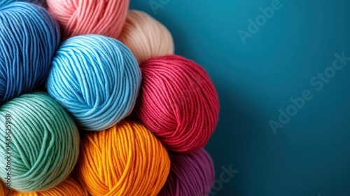This image features a vibrant assortment of yarn balls stacked together, showcasing a broad spectrum of colors ideal for artists, crafters, and hobbyists alike. photo