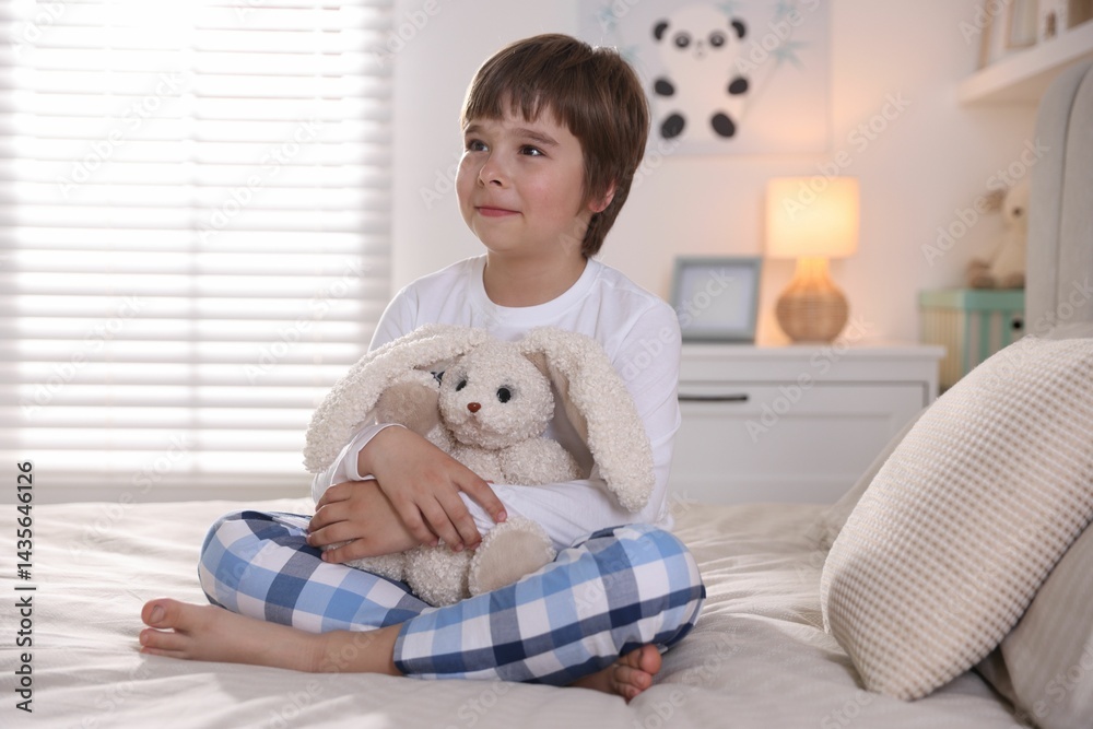 Cute boy with toy bunny in bed at home Cute boy with toy bunny in bed at home