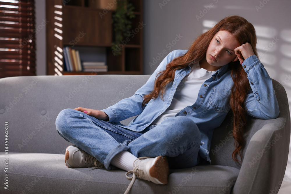 Obraz premium Sad teenage girl on sofa at home