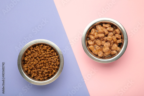 Wet and dry food for dogs and cats in silver bowl on pink background.