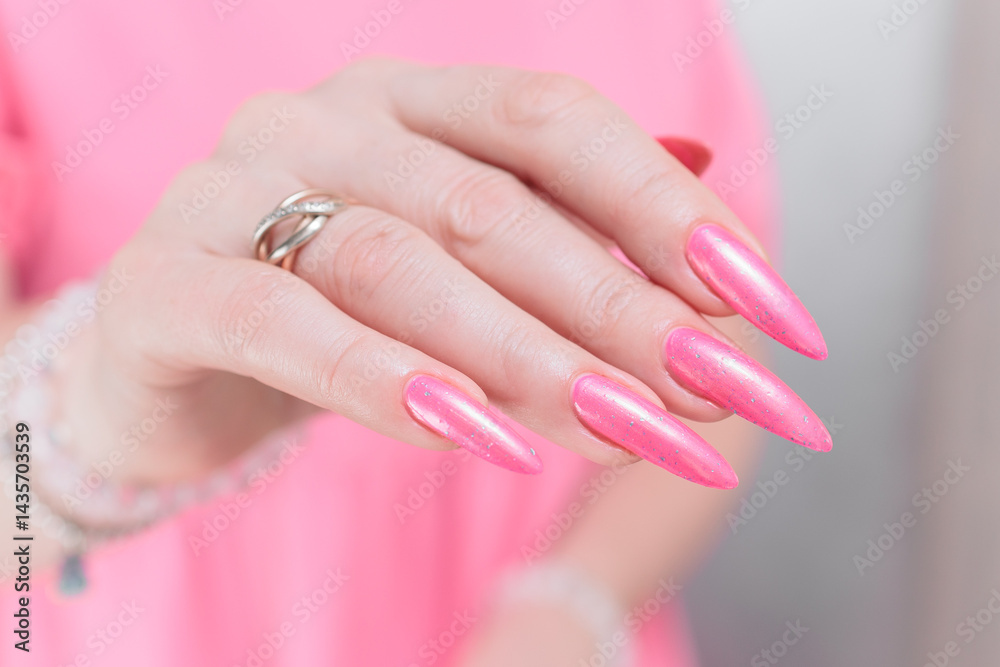 Fototapeta premium beautiful female hands with long nails and bright neon pink red nail polish
