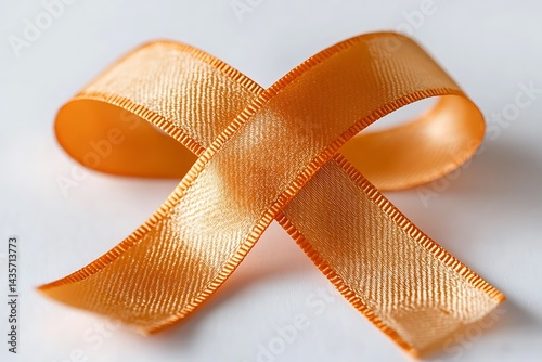 Golden ribbon symbolizing support awareness hopefulness on white background close up