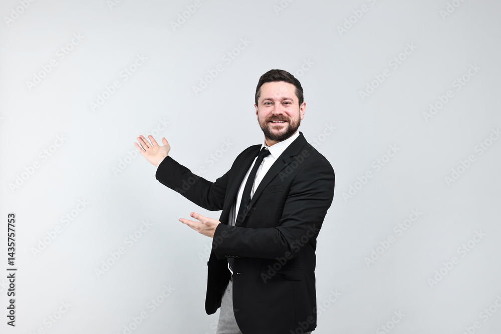 Happy businessman welcoming clients or partners on grey background Happy businessman welcoming clients or partners on grey background